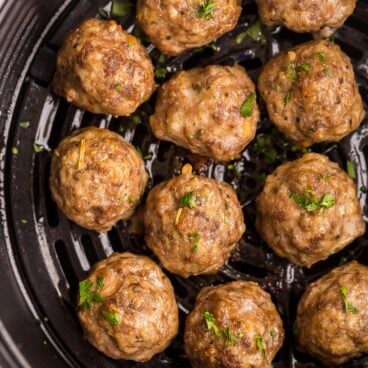 square image of air fryer meatballs in air fryer.