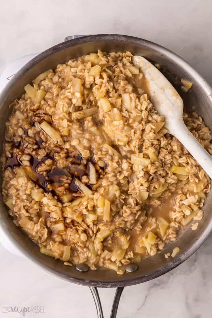 large pan of apple cinnamon oatmeal with spatula in it.