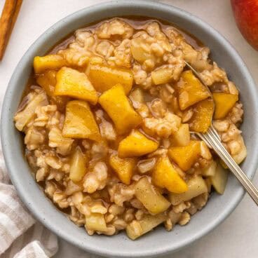 square image of apple cinnamon oatmeal with cooked apples on top.