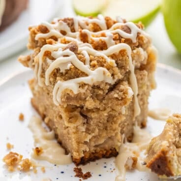 square image of slice of apple coffee cake on a plate.