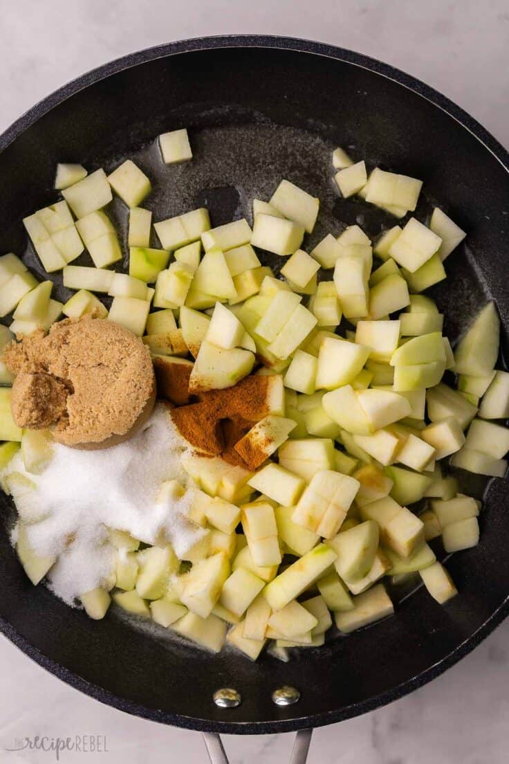 chopped apples, sugar and spices added to black pan.