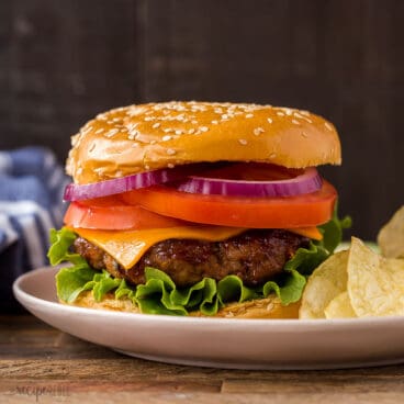 square image of the best burger recipe on a bun with toppings.