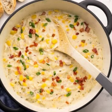 chicken corn chowder topped with bacon and green onions in a dutch oven.