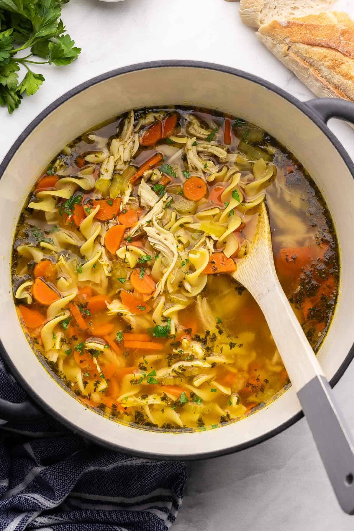 This homemade Chicken Noodle Soup is loaded with tender vegetables, shredded chicken, and egg noodles simmered in a delicious broth! It's the perfect hearty, healthy dinner for any night of the week. #soup #dinner #recipe | soup recipes | chicken recipes | chicken breast | chicken soup | comfort food | healthy dinner overhead image of chicken noodle soup recipe in a large soup pot.