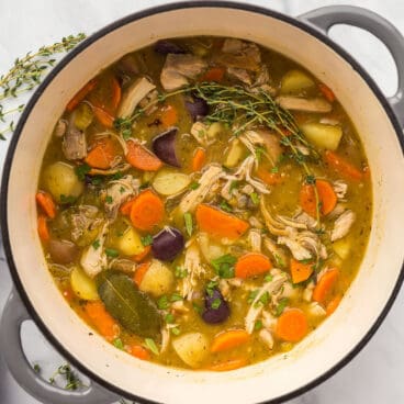 square overhead image of chicken stew in a dutch oven.