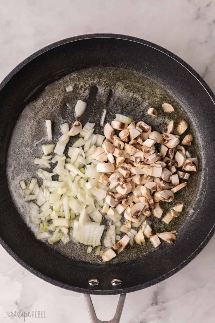 black pan filled with chopped onions and mushrooms.