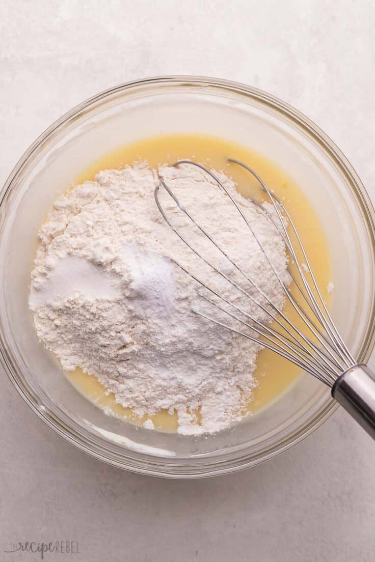 dry ingredients added to wet ingredients in glass mixing bowl.