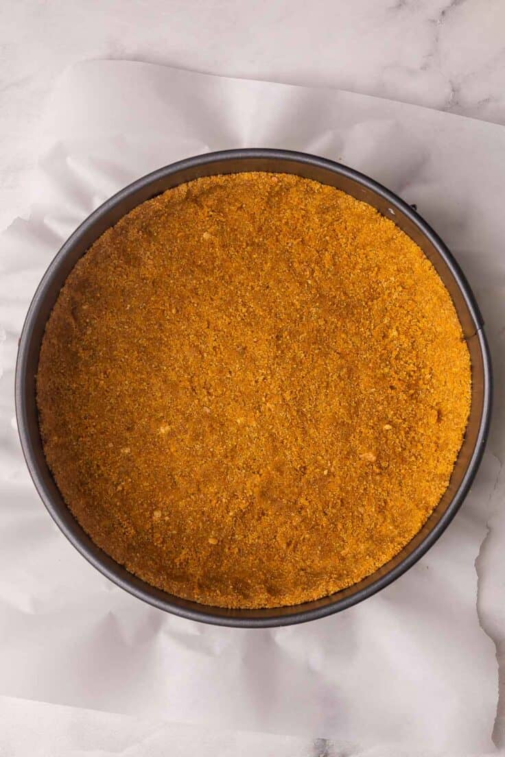 cheesecake pan with parchment paper and pressed in crust.