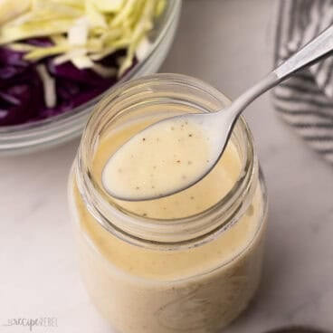 a spoon scooping coleslaw dressing out of jar.