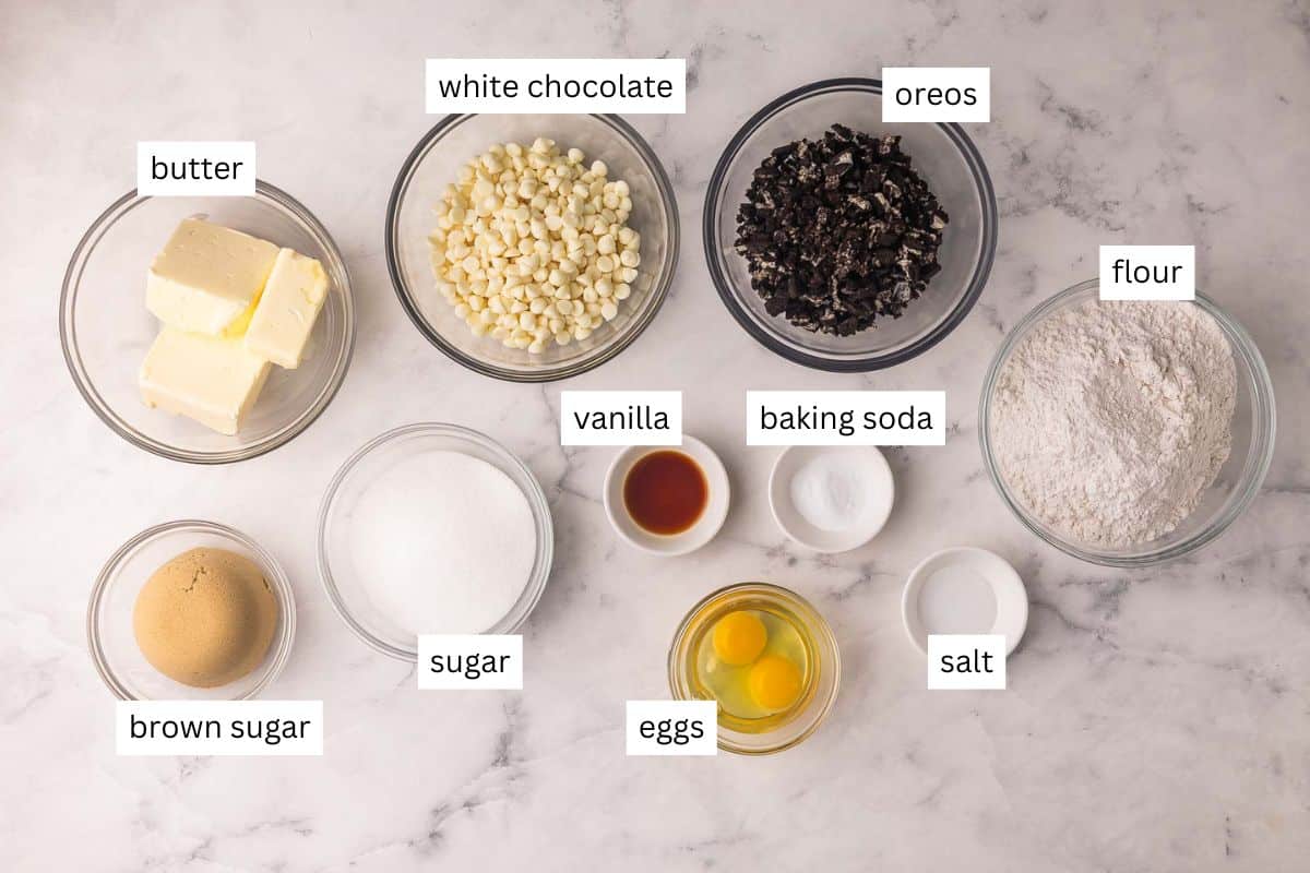These Cookies and Cream Cookies are everything you love about the classic combo in chewy cookie form! They're made with Oreo cookie chunks, white chocolate chips, and a basic cookie base for a fun twist on the iconic duo. | cookie recipe | oreo cookies | oreo desserts | baking from scratch | homemade cookies ingredients needed for cookies and cream cookies in bowls.