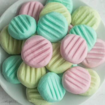 a plate stacked full of cream cheese mints.