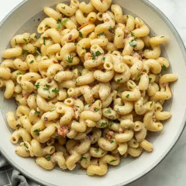 square image of creamy cavatappi pasta in grey bowl.