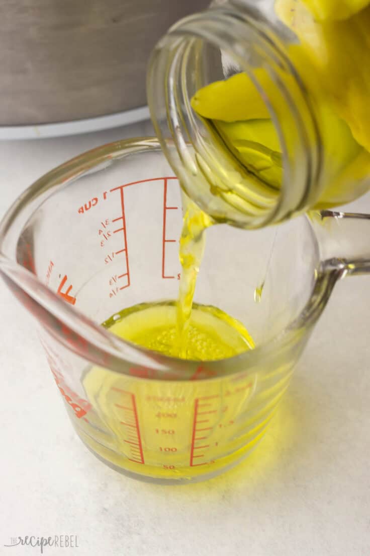 pouring the juice out of pepperoncini pepper jar.