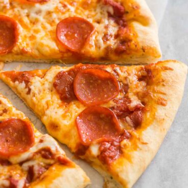 a slice of pepperoni pizza on a marble surface.