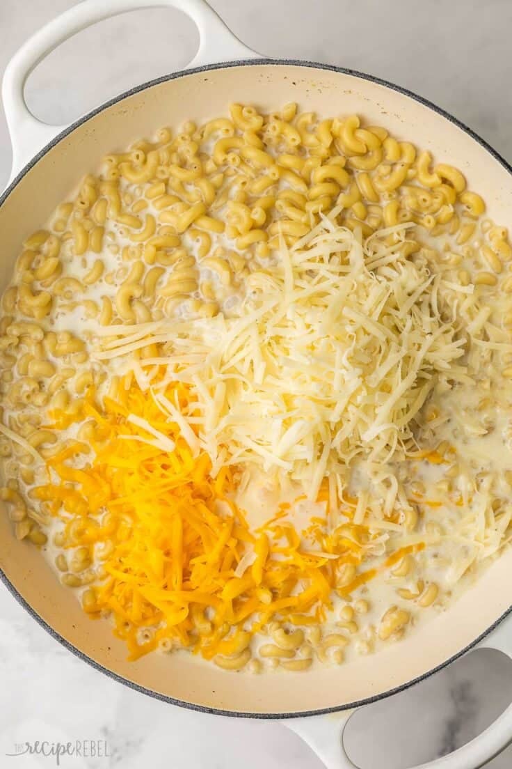 two kinds of shredded cheese added to cooked pasta.