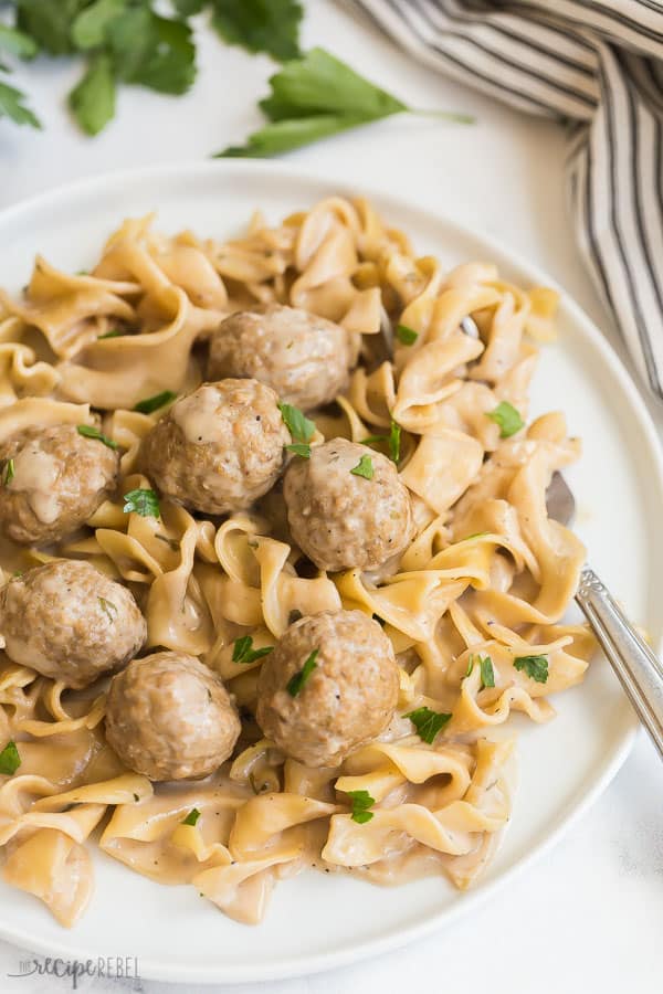 These Instant Pot Swedish Meatballs and Noodles are an easy one pot meal made in the pressure cooker! Made in 30 minutes or less. #instantpot #pressurecooker #meatballs #recipe #recipes instant pot swedish meatballs and noodles on white plate with fresh parsley