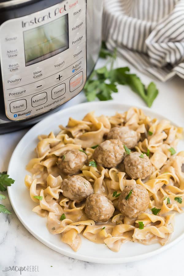 These Instant Pot Swedish Meatballs and Noodles are an easy one pot meal made in the pressure cooker! Made in 30 minutes or less. #instantpot #pressurecooker #meatballs #recipe #recipes instant pot swedish meatballs with pressure cooker in the background on white plate