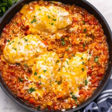 mango salsa chicken and rice in a pan topped with chopped parsley.