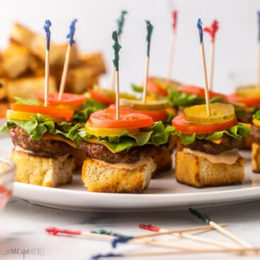 square image of mini cheeseburger skewers.