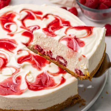 a piece of white chocolate raspberry cheesecake being served.