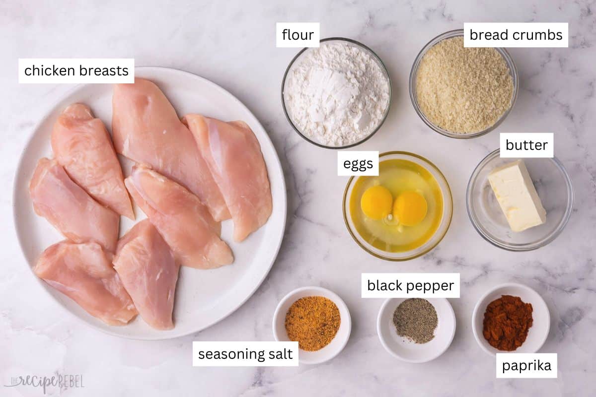 This easy Oven-Fried Chicken turns out perfectly crispy and juicy every time! The special seasoning blend tastes just like KFC, but it’s made with wholesome ingredients in your own kitchen. No deep fryer needed! #chicken #dinner #recipe | baked fried chicken | fried chicken breast | KFC copycat | chicken breast recipes | easy dinner ideas ingredients needed for oven fried chicken in bowls and plate.