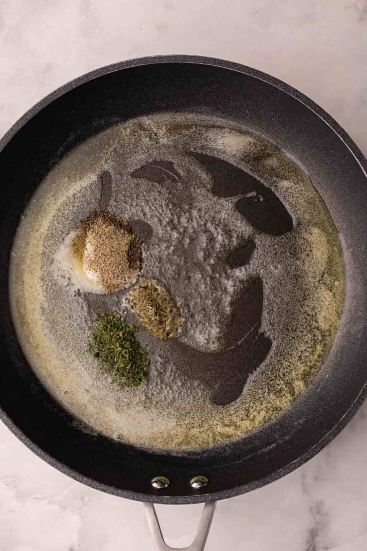 black pan with melted butter and spices added.