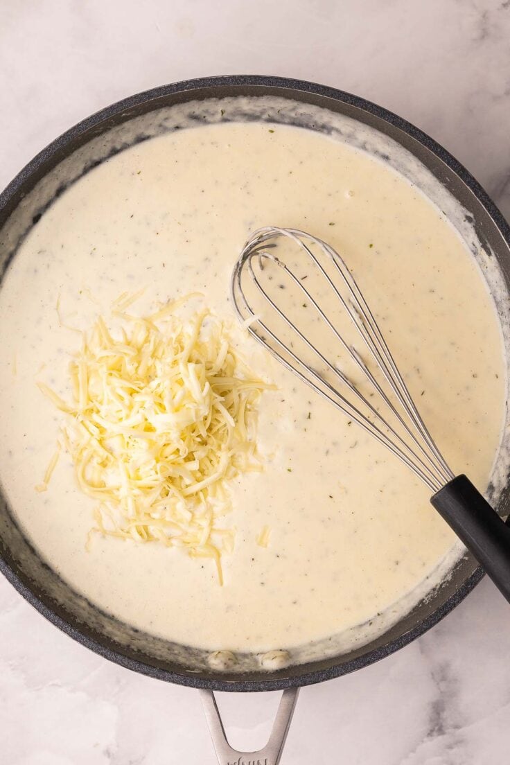 shredded cheese added to pan of cream sauce.