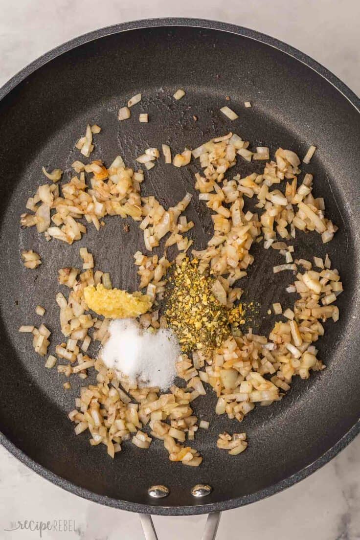spices added to other ingredients in frying pan.