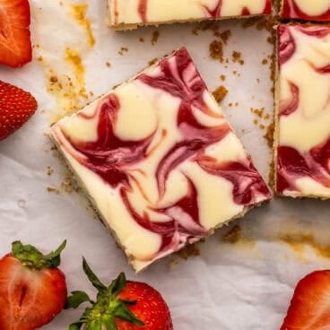 strawberry cheesecake swirl bars with strawberries beside.