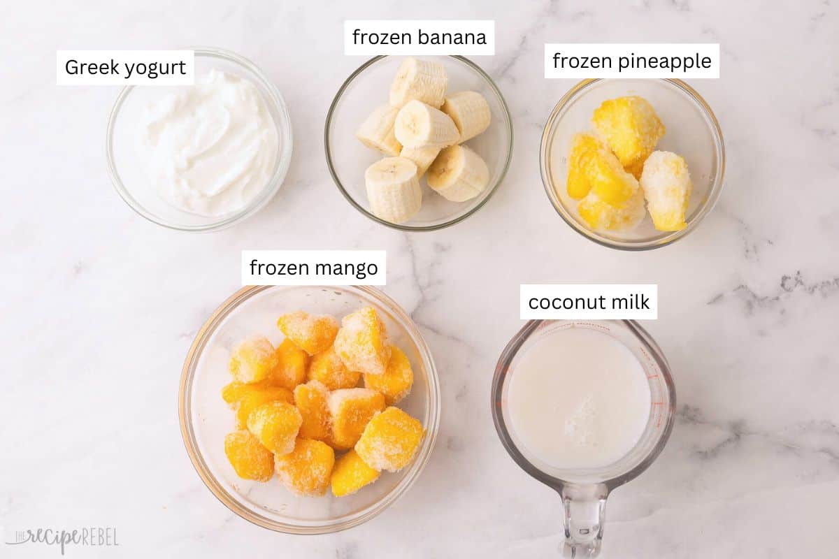 This Tropical Smoothie is made with banana, mango, pineapple, Greek yogurt, and coconut milk or pineapple juice! It's a great way to enjoy a taste of the tropics without leaving your kitchen. #smoothie #recipe #drink | drink recipes | smoothie recipes | fruit smoothies | healthy recipes | breakfast | healthy snack ingredients needed for tropical smoothie in bowls.