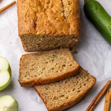 square image of apple zucchini bread with two slices.